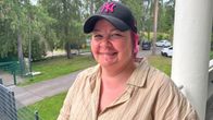 Henkilö seisoo ulkona kesäisessä ympäristössä ja käyttää New York Yankees -lippalakkia. Taustalla näkyy puita ja autoja.