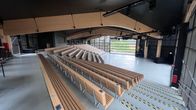 Suuri, katettu tapahtuma-areena, jossa on puisia penkkirivejä.