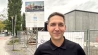 Tummahiuksinen mies hymyilee ja katsoo kameraan. Hänen takanaan on rakennustyömää. Mies on K-Citymarket kauppias Mika Somevaara. 