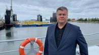 RMC toimitusjohtaja Mika Nieminen lähikuvassa, taustalla telakkanostureita.