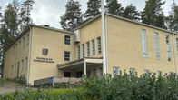 Parikkalan kunnantalon etupiha ja sisäänkäynti. Kunnan vaakuna on näkyvissä rakennuksen seinällä.