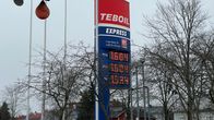 Tepoil Express -huoltoaseman kyltti näyttää polttoaineen hinnat. Taustalla näkyy puita ja rakennuksia. 