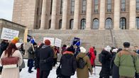 Ihmisiä eduskuntatalon edustalla mielenosoituksessa.