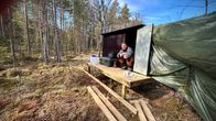 Man vid ett gömsle i skogen.
