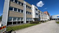 Kolmikerroksinen toimistorakennus aurinkoisena kesäpäivänä.