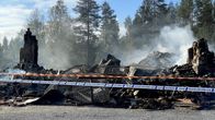 Tapionniemen kyläkartanon palaneista raunioista nousee savua ilmaan.