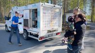 Jätskiauton myyjä Harri Taattola vie jäätelökassia autosta asiakkaille.