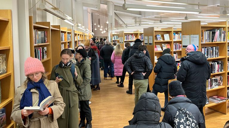 Vallilan kirjastossa ennakkoäänestyksessä jonottavia ihmisiä. Jonot kiertelevät kirjahyllyjen välissä.