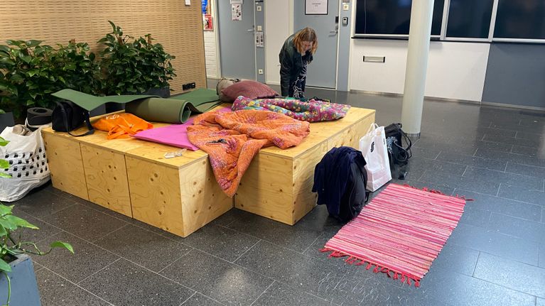 Opiskelija virittämässä yösijaa korkeakoulun aulassa.
