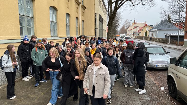 Joukko nuoria kadulla tiiviisti kokoontuneina.