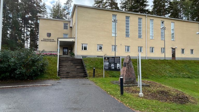 Parikkalan kunnantalon etupiha ja sisäänkäynti. Kunnan vaakuna on näkyvissä rakennuksen seinällä.