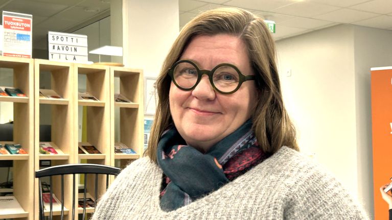 Lähikuvassa on Heinolan kaupunginhallituksen puheenjohtaja Kirsi Lehtimäki harmaassa villapaidassa ja hymyilee.