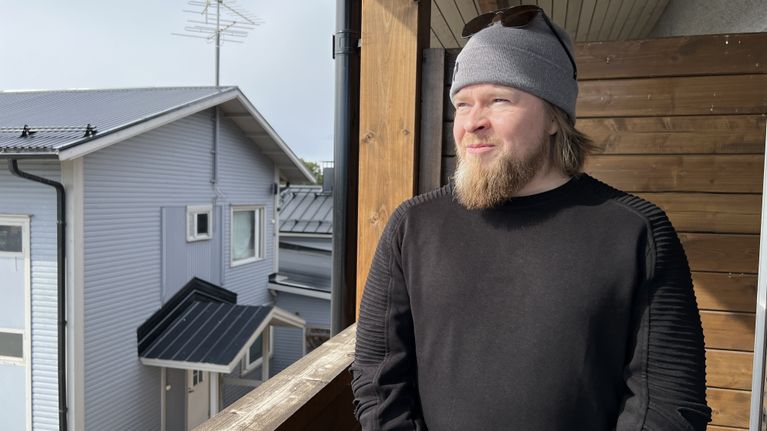 Henkilö seisoo parvekkeella aurinkoisena päivänä asuinalueella 4.5.2026 Karigasniemi.