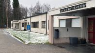 Ivalon terveyskeskuksen sisäänkäynti alkutalvisena päivänä, nurmikolla hieman lunta.