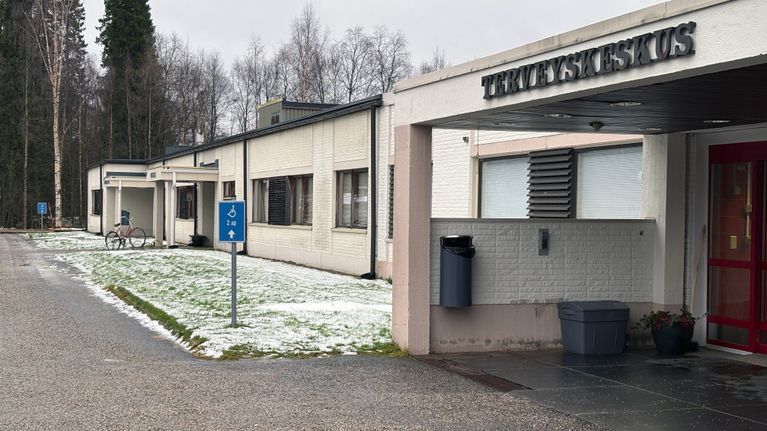 Ivalon terveyskeskuksen sisäänkäynti alkutalvisena päivänä, nurmikolla hieman lunta.