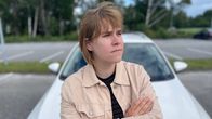 Sofia Tawast nojaa valkoiseen autoon kädet puuskassa. 