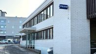 Kangasalan poliisiaseman valkoisen tiilirakennuksen sivu. Seinässä on sininen poliisikyltti.
