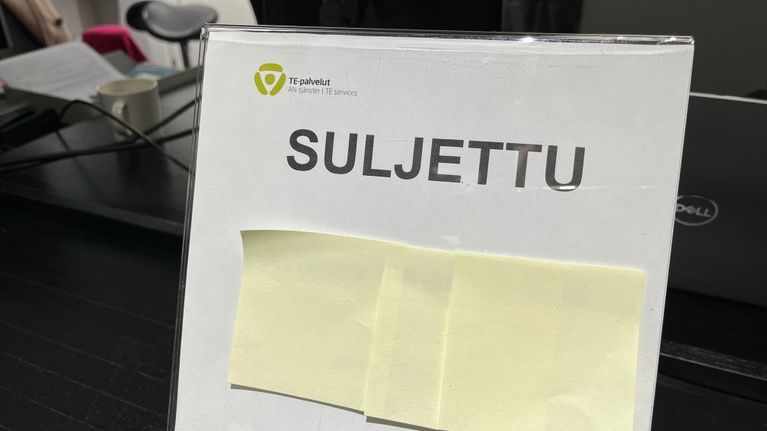 Pöydällä oleva kyltti, jossa on TE-palvelujen logo ja tekstit suljettu ja closed.