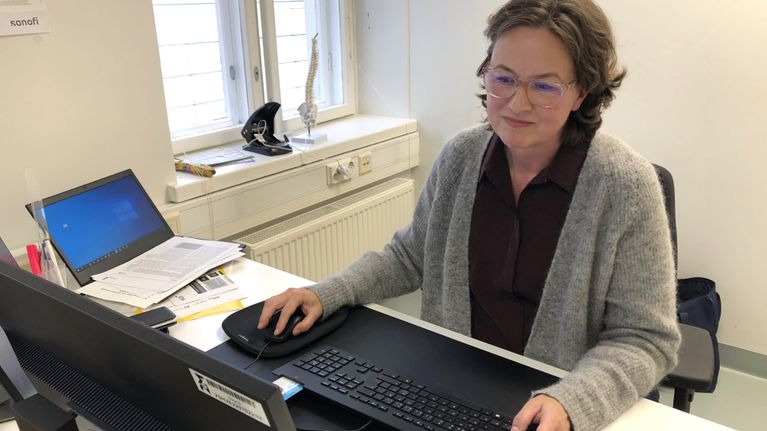 Riitta Ratia, läkare med ansvar för smittosamma sjukdomar hos välfärdsområdet, sitter och jobbar framför datorn.