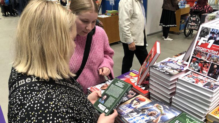 Kati ja Isabella Thorn katsovat kirjoja Turun kirjamessuilla 2023.