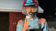 Kuvassa on rallikuljettaja Thierry Neuville, jolla on Huyndai-tiimin ajoasu ja kypärä yllään. Hän näyttää peukaloa ylöspäin, taustalla näkyy lumipeitteinen katto.