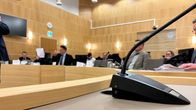 Joukko ihmisiä istuu käräjäoikeuden salissa.