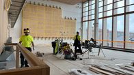 Rakennustyöntekijöitä työssään Tampereen kaupungin valtuustosalissa. Taustalla näkyy suojattu taideteos Orvokkimeri.