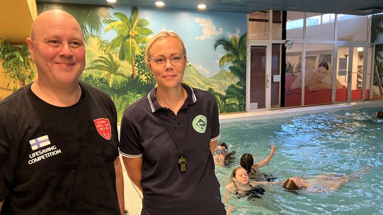 Hengenpelastuskerho Caribia Lifesaversin Sauli Suominen ja Uinti Turun kurssivastaava Elina Loponen katsovat kameraan Kylpylän Caribian lataan vieressä.