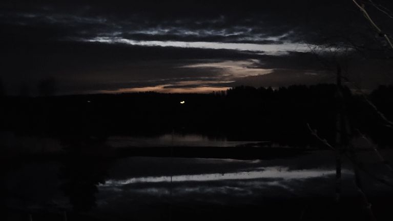 Pelto on veden vallassa yön hämärässä.