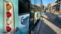 Siniseen linja-autoon nousee tummatakkinen nainen. Bussin takaosassa lukee Gyyt.