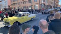 Amerikanautot ajavat Vaasan keskustan läpi vappuna. Suuri määrä ihmisiä katselee ympärillä.