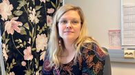 Nainen istuu työpöydän ääressä.