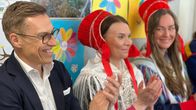 Presidentti Alexander Stubb taputtaa käsiään yhteen. Hänen vieressään istuu Nuorgamin koulun rehtori Laura Niittyvuopio-Valle.