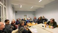 Stor grupp människor diskuterar åtgärder om stenbrott. 