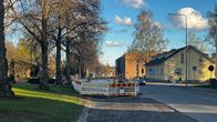 Keväinen katu, jonka laidassa näkyy rakennustyömaan aitaa. Vasemmalla kuvassa on kaivuri ja etualalla asvalttia on jyrsitty pois.