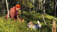 Toimittaja Päivikki Koskinen koiransa Uunon kanssa keräämässä sieniä syksyisessä metsässä.