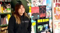 Hongkongilainen kirjakauppias Leticia Wong nojaa pöytään mietteliäänä kirjakaupassaan.