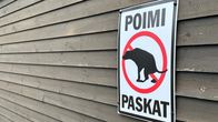 Harmahtavalla lautaseinällä oleva kyltti kehottaa koiranomistajia siivoamaan lemmikkiensä jätökset.