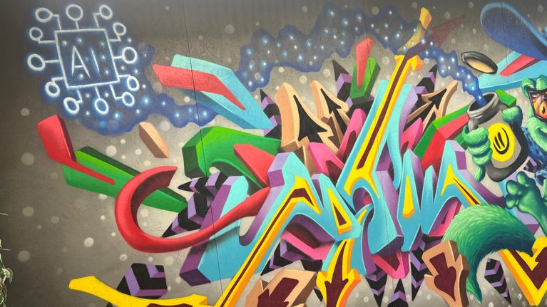 Det här är en färgglad graffitimålning som innehåller texten "AI", tillsammans med abstrakta mönster och former i många olika färger.