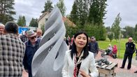 Kuvassa Janet Chang seisoo patsaan edessä,.