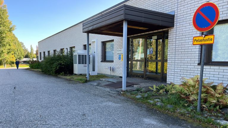 Ihminen kävelee kohti terveyaseman sisäänkäyntiä syksyllä.
