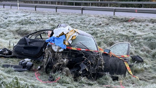 Henkilöauto on pahoin vaurioitunut tien reunalla, ympärillä on poliisin nauhaa ja maassa kuuraa.