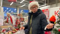 Nainen katsoo kädessään olevaa joulukoristetta.