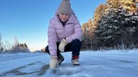 Nainen katselee kuoppaa Suomen surkeimmalla kylätiellä. 