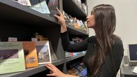 Italialainen Giulia Santelli järjestelee kirjoja työpaikallaan Juminkeon kulttuurikeskuksessa Kuhmossa.