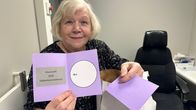 Vaalitoimikunnan puheenjohtaja Sirpa Koivisto esittelee aluevaalien äänestyslipuketta.