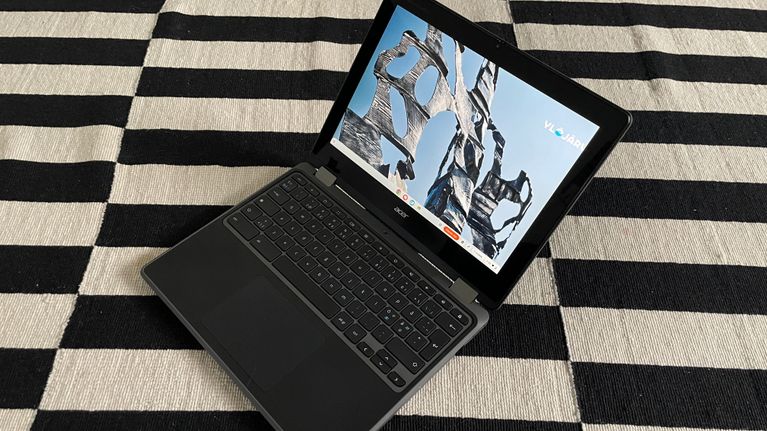 Chromebook on lattialla mustavalkoisen maton päällä.