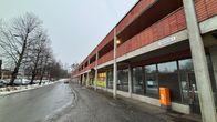 Puijonlaakson keskuksen alueella sijaitseva kaksikerroksinen, punatiilinen liikerakennus.