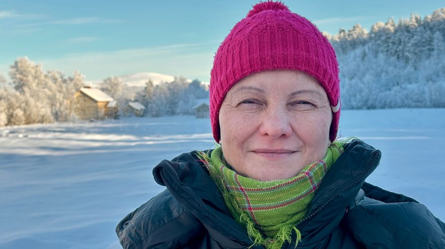 Nainen katsoo kameraan, taustalla tunturimaisema. Erva Niittyvuopio. 