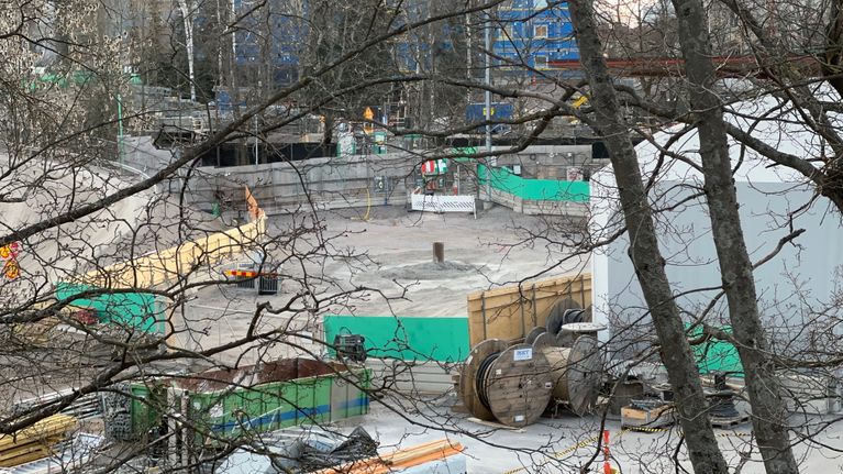 Työmaa-alue, jonka keskellä on tasainen harmaa hiekka-alue, josta törröttää metallinen metrin pituinen putki suoraan ylös.